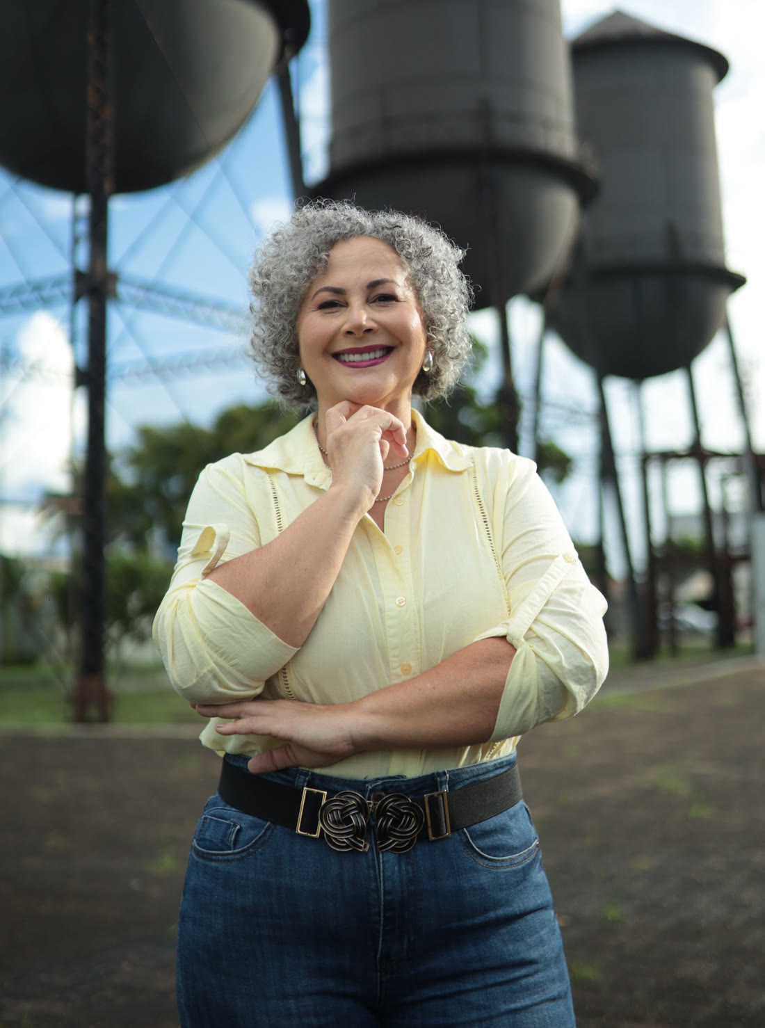 Laura Marcela, candidata a Deputada Estadual por Rondônia, sorrindo em frente às caixas d'água históricas de Porto Velho.